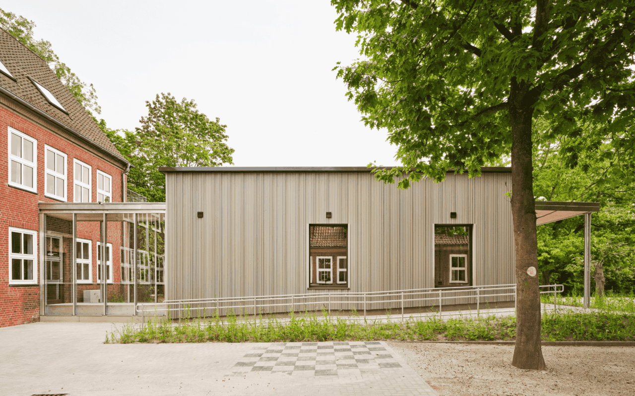 Die Mensa mit einer vorgehängten Holzfassade ist mit dem Bestandsbau verbunden.