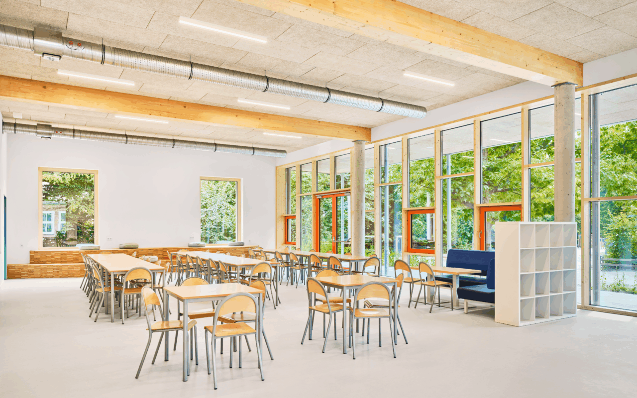 The dining hall, with its glass façade, leads to the playground of the Breitenauschule Plön school.